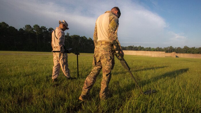 Senior Airman Christian Hulsey, an explosive ordnance technician with 4th civil engineer squadron, sweeps the ground for unexploded ordnance alongside a Marine with 2nd Explosive Ordnance Disposal Company during a field exercise at Camp Lejeune, N.C., June 30, 2016. The field exercise was a weeklong event that served as an evaluation of the skills and capabilities as EOD technicians.  