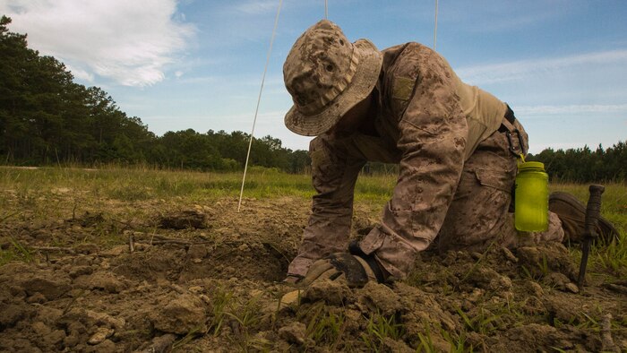 A Marine with 2nd Explosive Ordnance Disposal Company unearths a 155mm mortar round during a field training exercise at Marine Corps Base Camp Lejeune, N.C., June 30, 2016. The exercise consisted of multiple tasks that an EOD technician might face while deployed, which tested their abilities to safely find, evaluate and dispose of unexploded ordnance. 