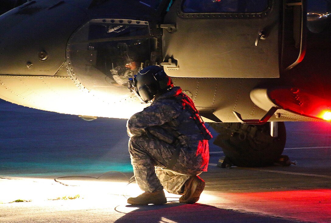 A U.S. Army UH-60 Black Hawk helicopter crew member assigned to the Puerto Rico Army National Guard inspects the aircraft prior to conducting night flight training at the aviation support facility in Isla Grande, Puerto Rico, Sept. 2, 2014. (U.S. Army National Guard photo by Sgt. Pablo Pantoja/Released)