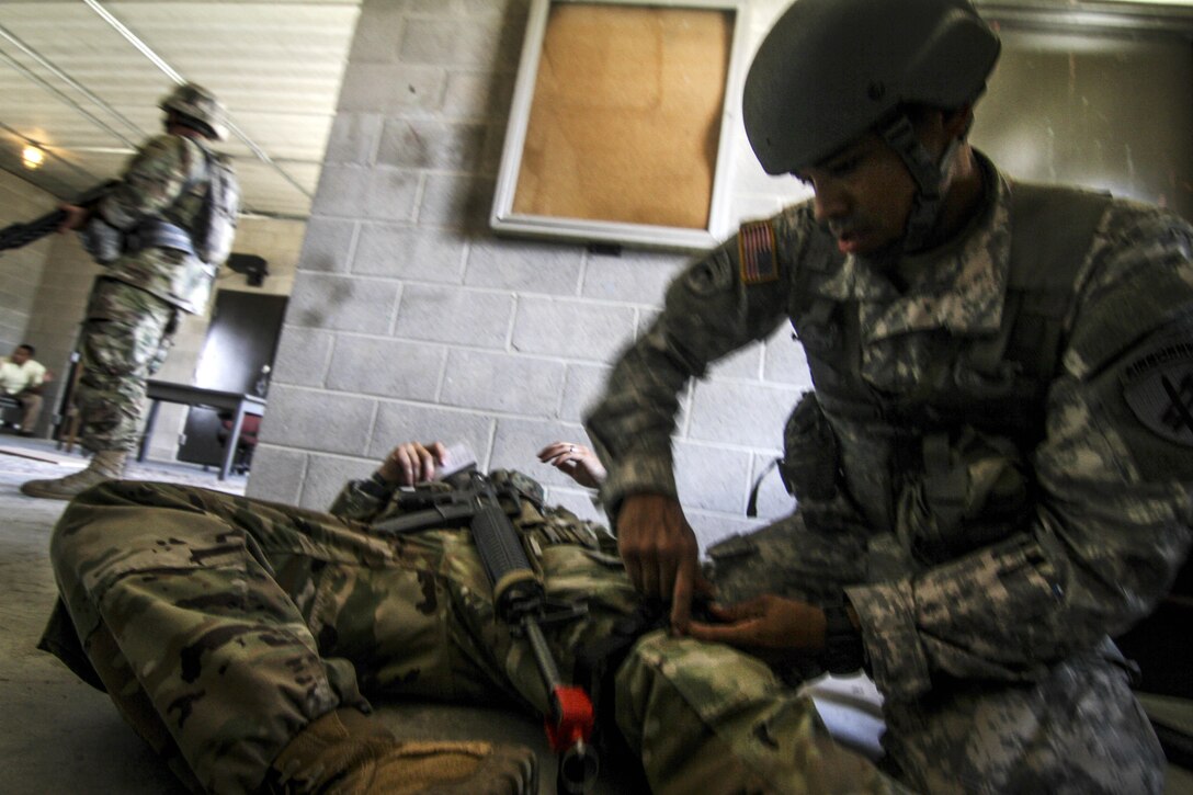 Army Reserve Staff Sgt. Mario Santos, right, provides medical care to a simulated casualty during Exercise Gridiron at Joint Base McGuire-Dix-Lakehurst, N.J., June 27, 2016. Santos is assigned to the 404th Civil Affairs Battalion. Air National Guard photo by Tech. Sgt. Matt Hecht