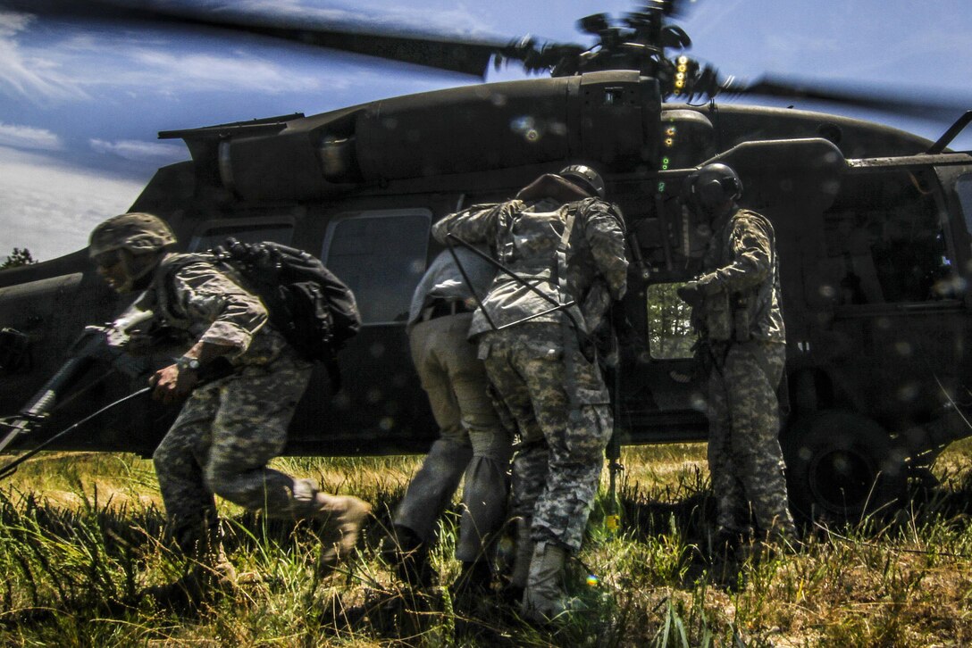 Soldiers load a simulated casualty onto a UH-60 Black Hawk helicopter during Exercise Gridiron at Joint Base McGuire-Dix-Lakehurst, N.J., June 27, 2016. Air National Guard photo by Tech. Sgt. Matt Hecht