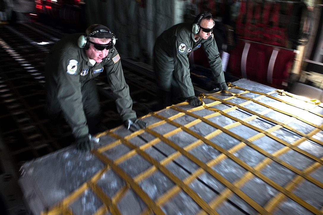 Master Sgt. Rob Taylor and Staff Sgt. Ken Toney, both C-130 Hercules loadmasters assigned to the West Virginia National Guard's 130th Airlift Squadron, push a pallet onto a K-loader during Exercise Turbo Distribution, which takes place between Oct. 27-29, Gulfport, Miss., Oct. 28, 2015. The U.S. Transportation Command exercise tests the Joint Task Force Port-Opening's ability to deliver and distribute cargo during humanitarian relief operations.

