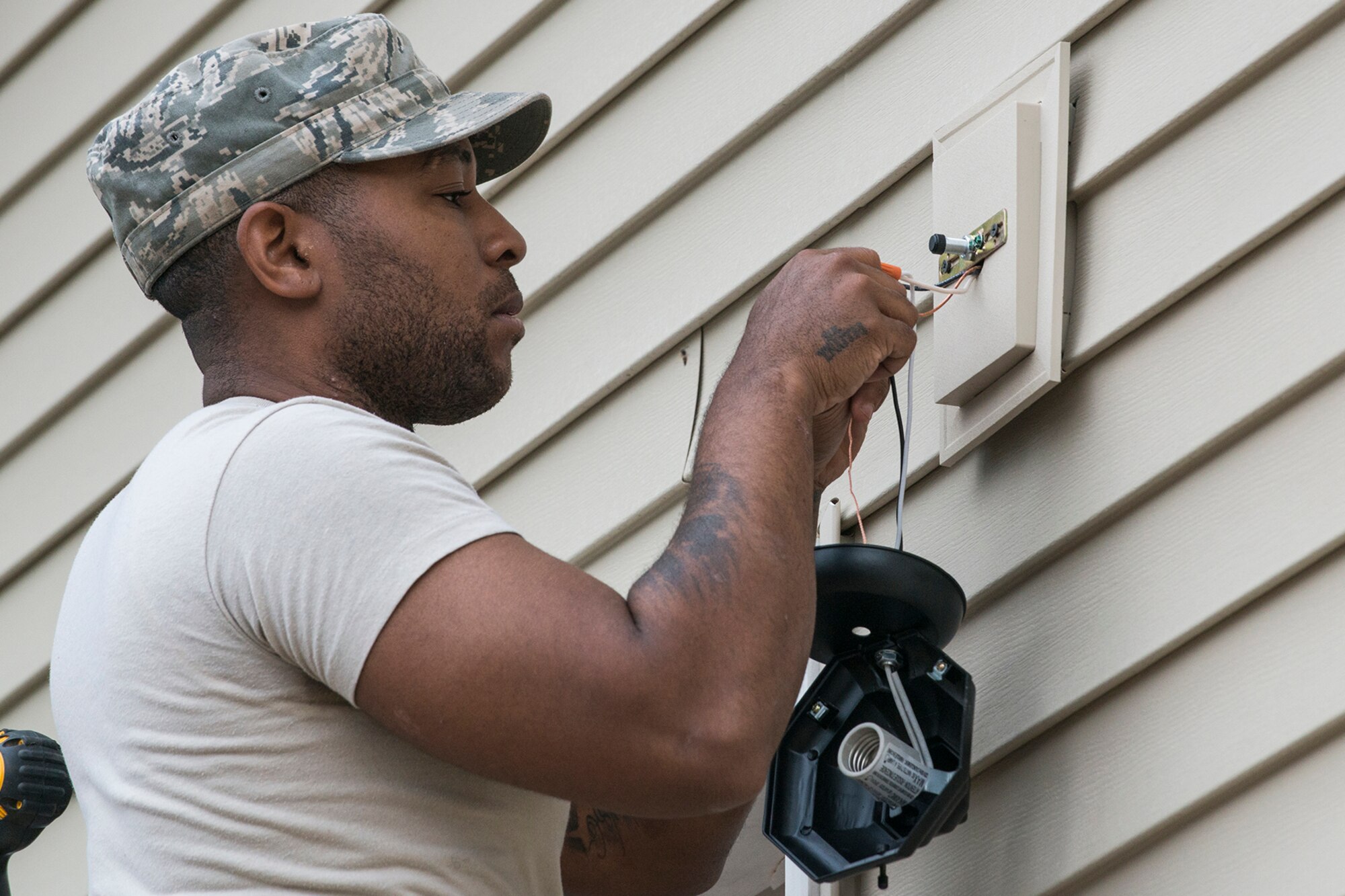 U.S. Air Force Staff Sgt. Deangelo Law, a 307th Civil Engineering Squadron (CES) electrician, installs an exterior light on the new office building that is being built at the Chenango County Fairgrounds, Norwich, N.Y., June 28, 2016. The 307th CES is an Air Force Reserve squadron assigned under the 307th Bomb Wing at Barksdale Air Force Base, La., and is in Norwich to participate in a community restoration project in support of the Innovative Readiness Training Program.  (U.S. Air Force photo by Master Sgt. Greg Steele/Released)