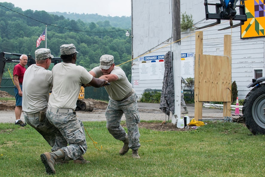 U.S. Air Force Airmen from the 307th Civil Engineering Squadron (CES) strain to pull new electrical lines through conduit laid underground at the Chenango County Fairgrounds, Norwich, N.Y., June 28, 2016. The 307th CES is an Air Force Reserve squadron assigned under the 307th Bomb Wing at Barksdale Air Force Base, La., and is in Norwich to participate in a community restoration project in support of the Innovative Readiness Training Program.  (U.S. Air Force photo by Master Sgt. Greg Steele/Released)
