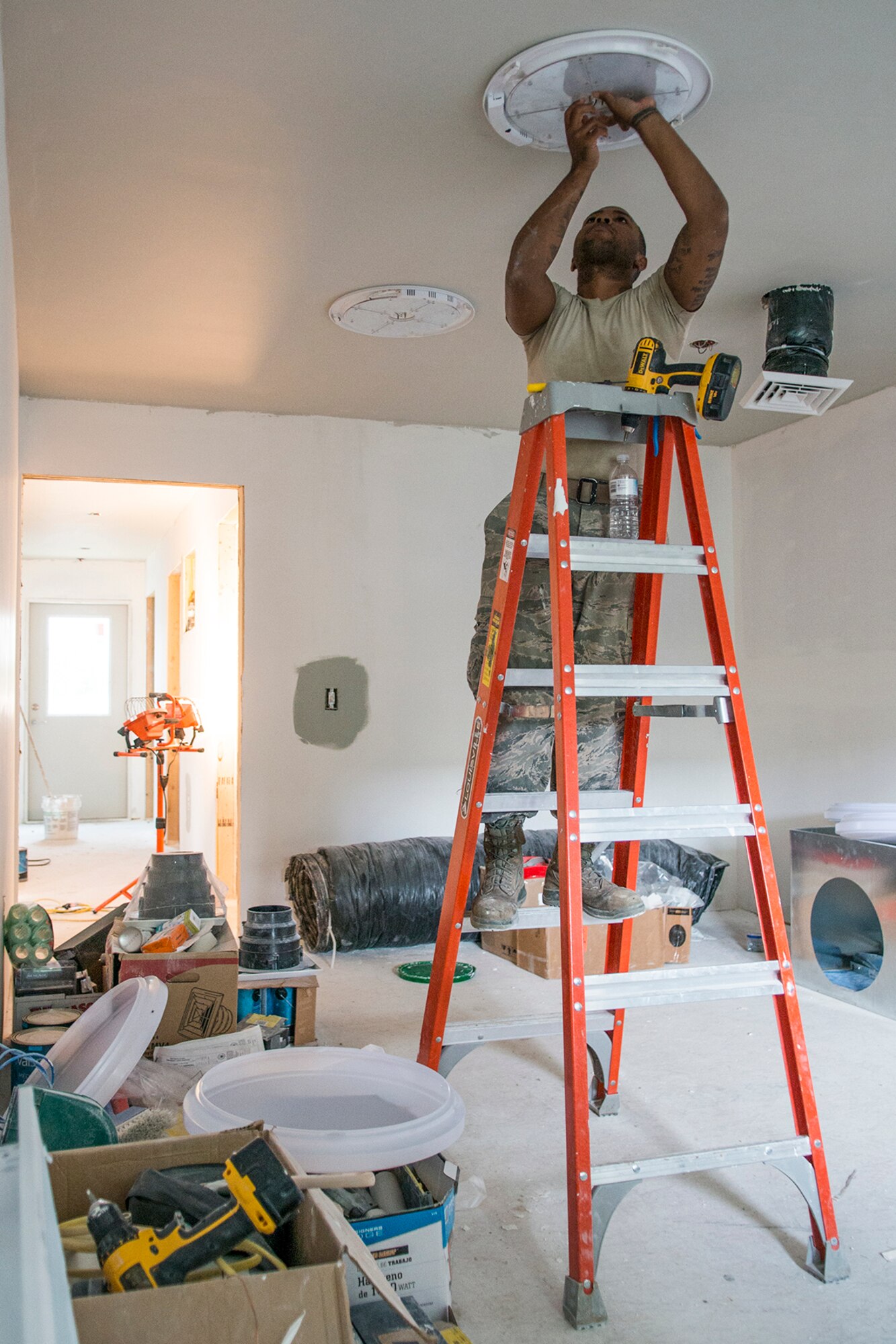 A U.S. Air Force Airman assigned to the 307th Civil Engineering Squadron (CES) installs an interior light in a new office building that was built at the Chenango County Fairgrounds, Norwich, N.Y., June 28, 2016. The 307th CES is an Air Force Reserve squadron assigned under the 307th Bomb Wing at Barksdale Air Force Base, La., and is in Norwich to participate in a community restoration project in support of the Innovative Readiness Training Program.  (U.S. Air Force photo by Master Sgt. Greg Steele/Released)