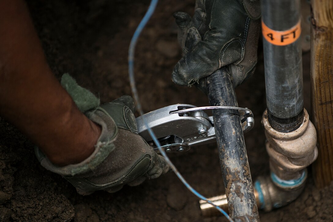A U.S. Air Force Airman from the 307th Civil Engineering Squadron (CES) trims a water line prior to installing  a water faucet at the Chenango County Fairgrounds, Norwich, N.Y., June 29, 2016. The 307th CES is an Air Force Reserve squadron assigned under the 307th Bomb Wing at Barksdale Air Force Base, La., and is in Norwich to participate in a community restoration project in support of the Innovative Readiness Training Program.  (U.S. Air Force photo by Master Sgt. Greg Steele/Released)