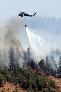 A California National Guard UH-60 Blackhawk crew drops water on the Ponderosa wildfires near Redding, Calif., in 2012. Guard assets are currently working to fight fires in the state.