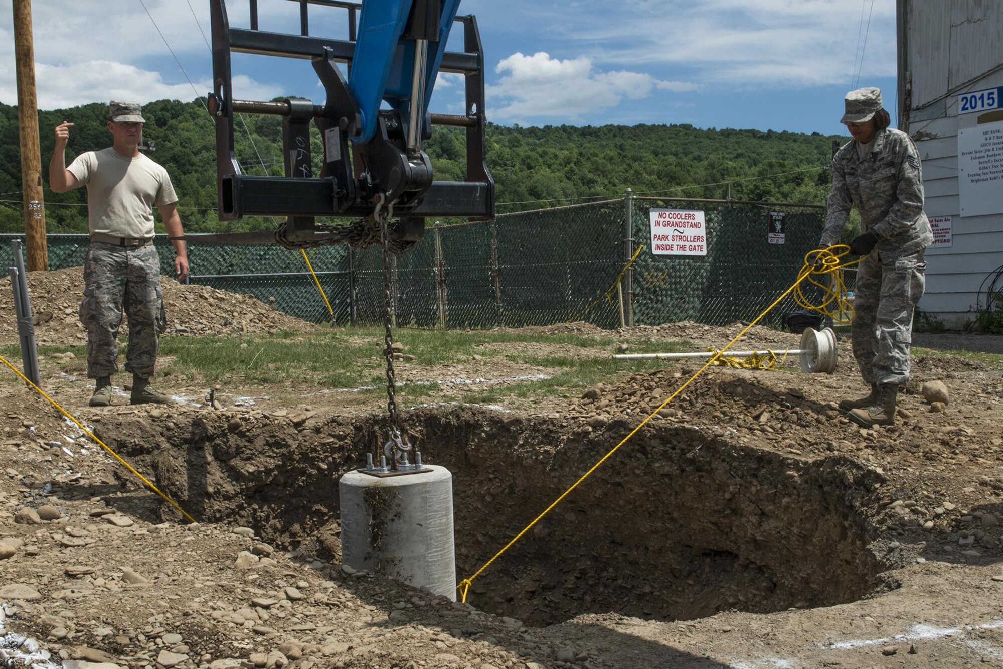U.S. Air Force Airmen from the 307th Civil Engineering Squadron (CES) carefully guide a 1,400 pound concrete pillar into a hole where it will provide a solid base for a new light pole at the Chenango County Fairgrounds, Norwich, N.Y., June 30, 2016. The 307th CES is an Air Force Reserve squadron assigned under the 307th Bomb Wing at Barksdale Air Force Base, La., and is in Norwich to participate in a community restoration project in support of the Innovative Readiness Training Program.  (U.S. Air Force photo by Master Sgt. Greg Steele/Released)