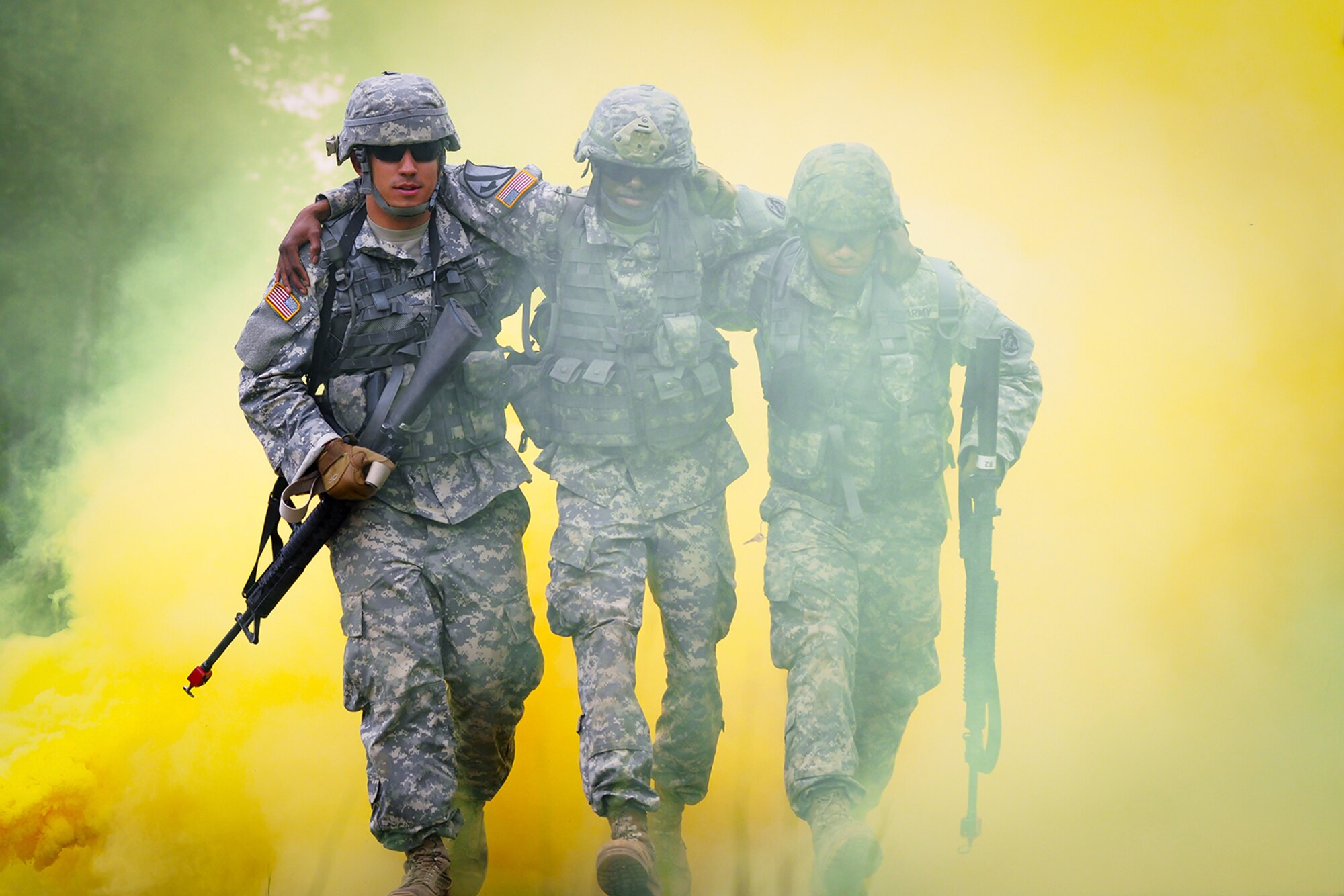 Army Pfc. Tim Hofmann, a native of Atwater, Minn., left, and Spc. Alex Sidoa, a native of Houston, Texas, help Army Sgt. Michael Barnes, a native of Minneapolis, Minn., through the smoke marking a simulated casualty extraction point on a Situation Exercise Training lane during the Ready Warrior Competition at Camp Madbull on Joint Base Elmendorf-Richardson, Alaska, Thursday, June 23, 2016.  The three-day competition tested teams of Soldiers assigned to U.S. Army Alaska’s 17th Combat Sustainment Support Battalion in physical fitness, small arms proficiency, land navigation, and small-unit tactics as well as other Soldier skills. (U.S. Air Force photo/Justin Connaher)