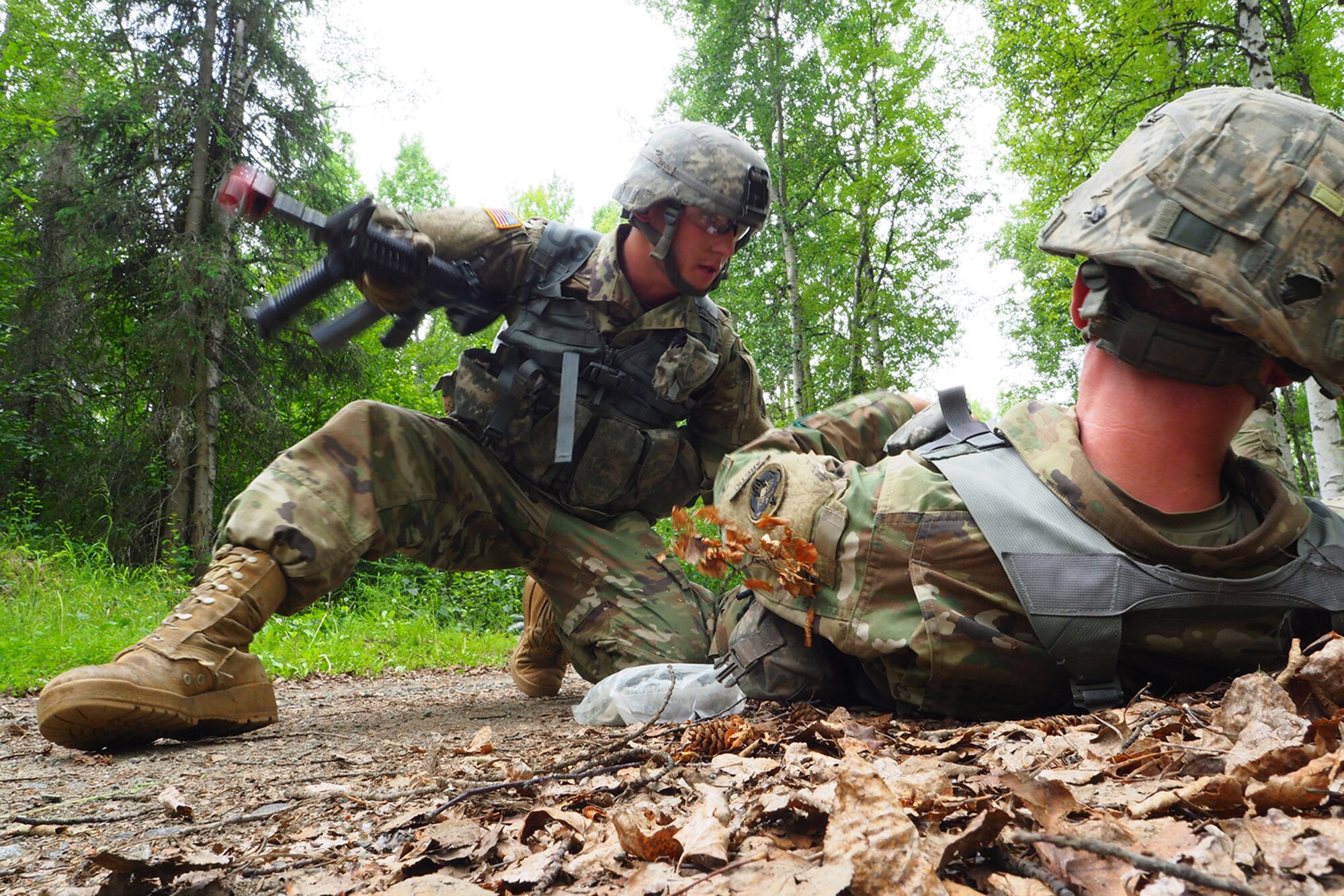 Spc. Colton Gobel, a native of Touchet, Wash., assigned to the 539th Composite Truck Company (Light), 17th Combat Sustainment Support Battalion, U.S. Army Alaska, checks the wounds of a simulated casualty on a Situation Exercise Training lane during the Ready Warrior Competition at Camp Madbull on Joint Base Elmendorf-Richardson, Alaska, Thursday, June 23, 2016.  The three-day competition tested teams of Soldiers in physical fitness, small arms proficiency, land navigation, and small-unit tactics as well as other Soldier skills. (U.S. Air Force photo/Justin Connaher)