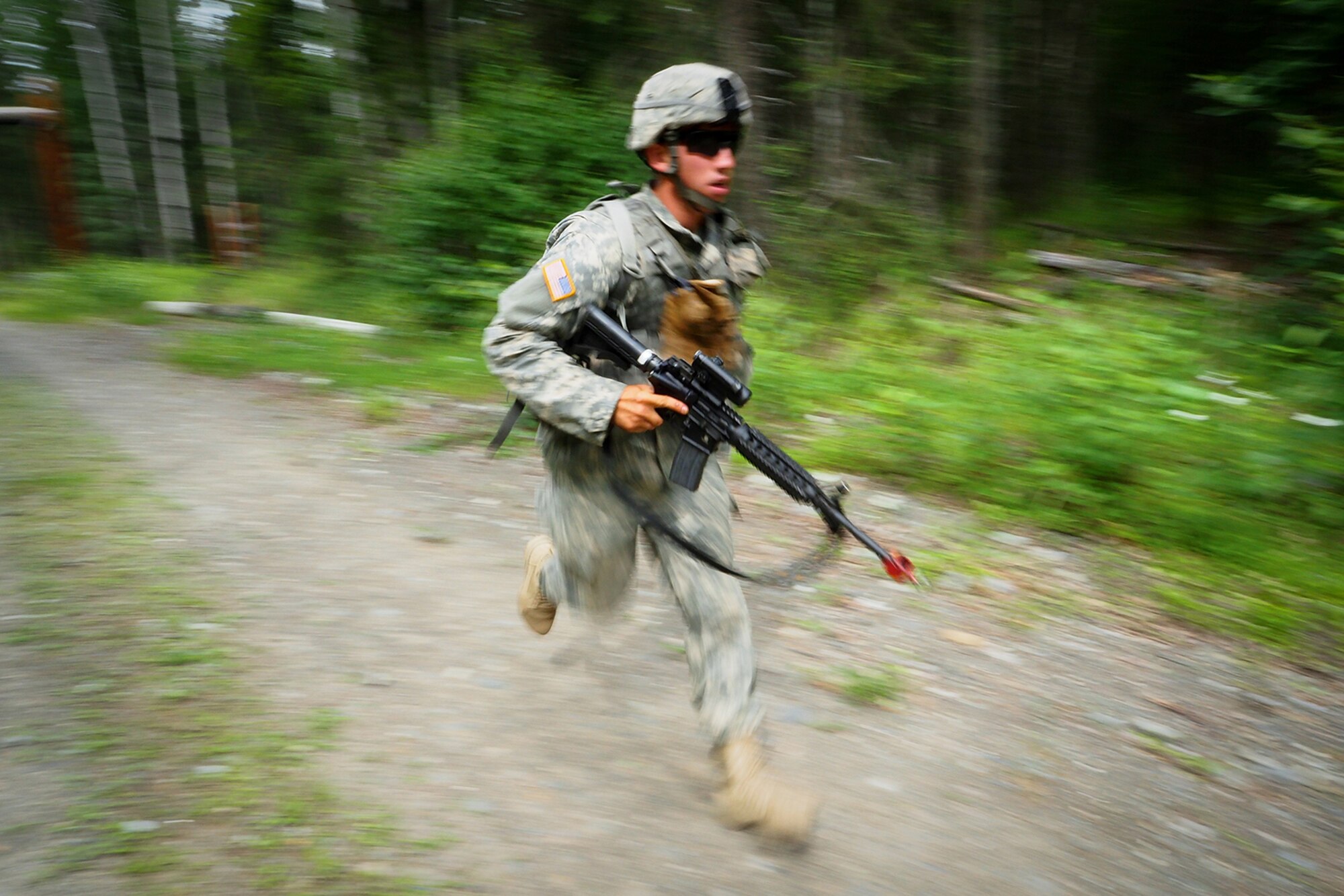 A soldier assigned to the 17th Combat Sustainment Support Battalion, U.S. Army Alaska, rushes forward toward an objective on a Situation Exercise Training lane during the Ready Warrior Competition at Camp Madbull on Joint Base Elmendorf-Richardson, Alaska, Thursday, June 23, 2016.  The three-day competition tested teams of Soldiers in physical fitness, small arms proficiency, land navigation, and small-unit tactics as well as other Soldier skills. (U.S. Air Force photo/Justin Connaher)