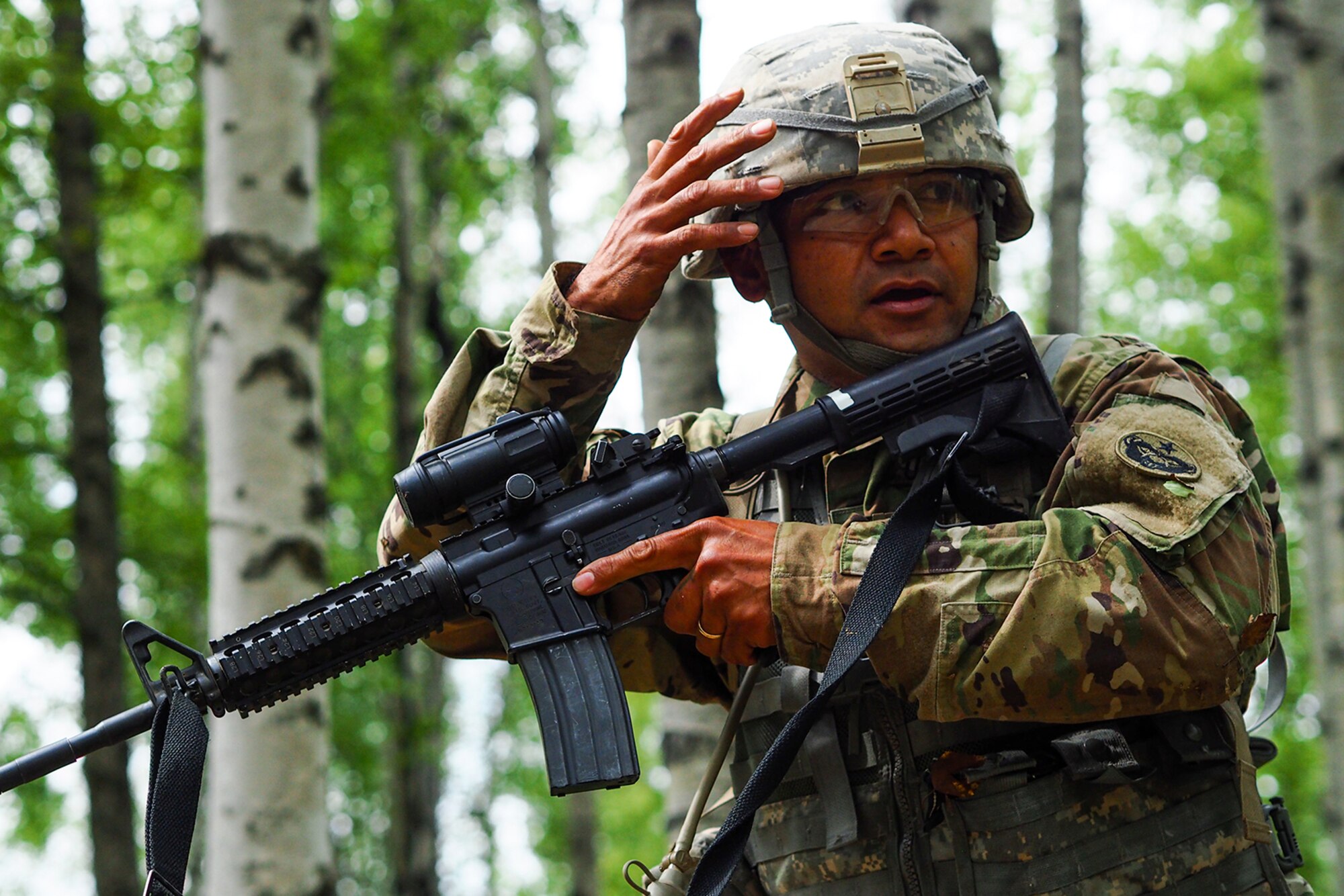 Army Sgt. Norbert Iriarte, a native of Mangilao, Guam, assigned to the 17th Combat Sustainment Support Battalion, U.S. Army Alaska, gives a hand signal to his team on a Situation Exercise Training lane during the Ready Warrior Competition at Camp Madbull on Joint Base Elmendorf-Richardson, Alaska, Thursday, June 23, 2016.  The three-day competition tested teams of Soldiers in physical fitness, small arms proficiency, land navigation, and small-unit tactics as well as other Soldier skills. (U.S. Air Force photo/Justin Connaher)