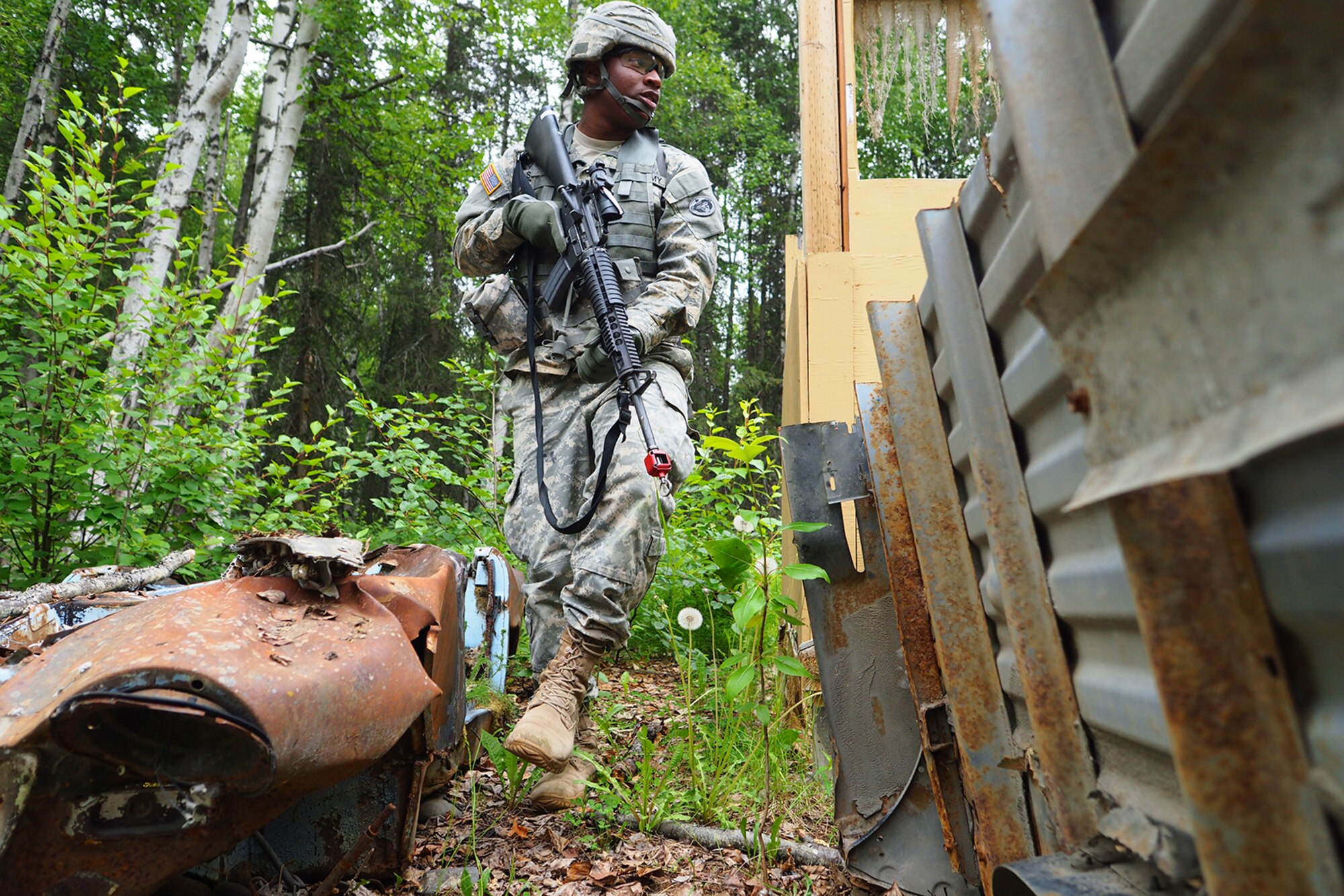 Army Pfc. Ichwandt Savage, a native of Philadelphia, Pa., assigned to the 486th Movement Control Team, 17th Combat Sustainment Support Battalion, U.S. Army Alaska, moves between obstacles on a Situation Exercise Training lane during the Ready Warrior Competition at Camp Madbull on Joint Base Elmendorf-Richardson, Alaska, Thursday, June 23, 2016.  The three-day competition tested teams of Soldiers in physical fitness, small arms proficiency, land navigation, and small-unit tactics as well as other Soldier skills. (U.S. Air Force photo/Justin Connaher)