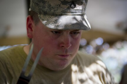 Pfc. Jordan Myers, a U.S. Army Reserve culinary specialist from Canal Winchester, Ohio, with the 391st Military Police Battalion, scrutinizes a meat thermometer during the Philip A. Connelly Competition at Camp Atterbury, Indiana, June 23. The 391st is representing the 200th MP Command in the competition, part of a training program designed to improve professionalism and recognize excellence, which augments the quality of food and food service within the Army. The top four food service teams will continue to the U.S. Army Reserve level competition. (U.S. Army photo by Sgt. Audrey Hayes)