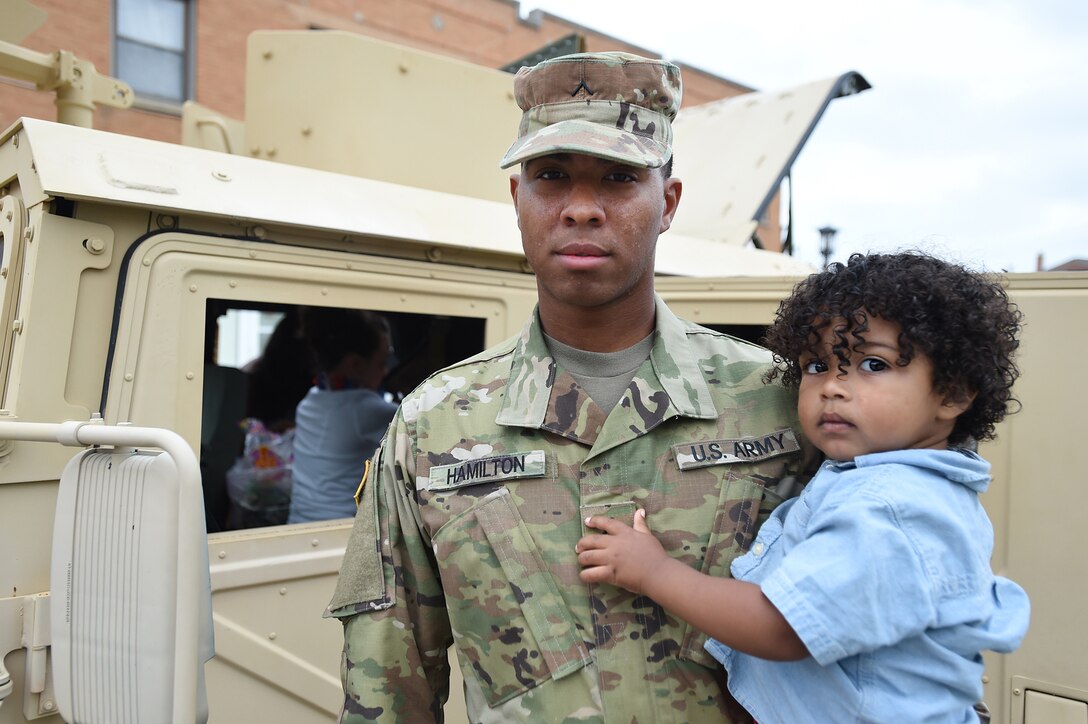 Pvt. Jahari Hamilton, a construction engineer assigned to the 317th Engineer Battalion, Homewood, Illinois, holds his one-year-old son, Brenton before the Villa Park Independence Day parade, July 4, 2016.
(U.S. Army photo by Spc. David Lietz/Released)