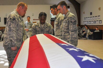Honor guard trainees practice folding the flag during a pallbearer training exercise.  Most Airmen are just out of technical school and beginning their careers when they start training for the honor guard. Members are chosen for their steadfast dedication to the integrity, service and excellence required to bring honor to the ceremonies the Air Force holds dear. (U.S. Air Force Photo/Senior Airman Kristin Kurtz)
