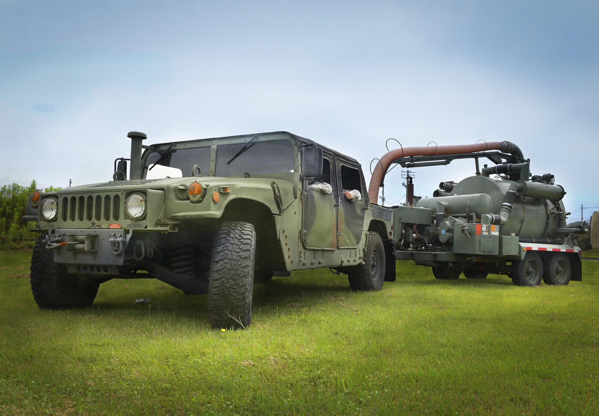 Airman 1st Class Alexander Love Gaunt, 374th Civil Engineer Squadron water and fuels systems maintenance civil engineer, operates a Humvee towing equipment for clearing sewage lines at Yokota Air Base, Japan, June 29, 2016. The 374 CES and 374th Logistics Readiness Squadron use Humvees, a versatile, all-terrain utility vehicle, to pull heavy equipment or navigate off-road terrain for situations such as retrieving parachutes from rugged drop zones. (U.S. Air Force illustration by Airman 1st Class Baker/Released)