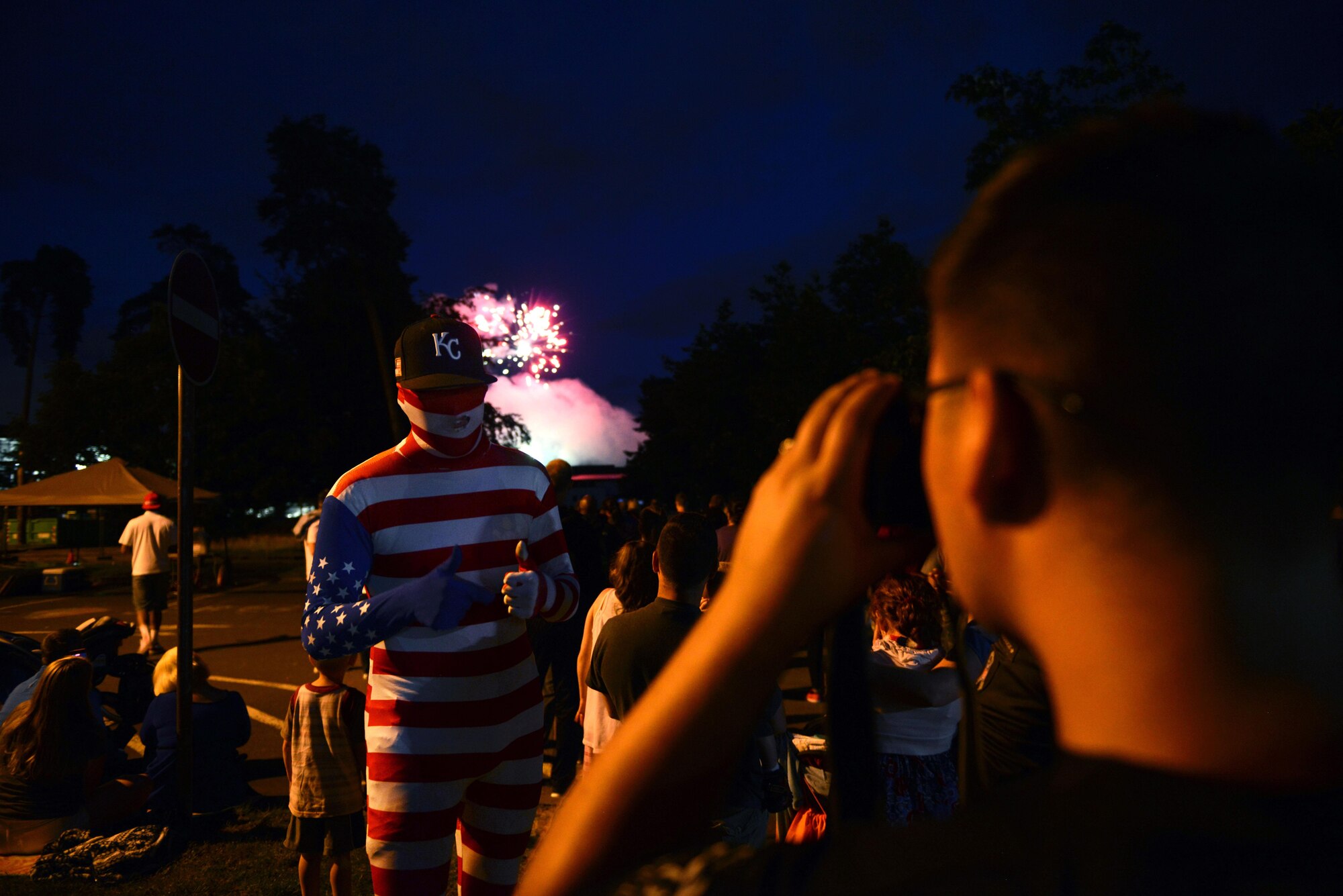 A man in an American flag suit poses for a picture during the Freedom Fest 2016fireworks display at Ramstein Air Base, Germany, July 4, 2016. The Independence Day celebration included a variety of foods, games, rides and fireworks for Kaiserslautern Military Community members. (U.S. Air Force photo/ Airman 1st Class Joshua Magbanua)