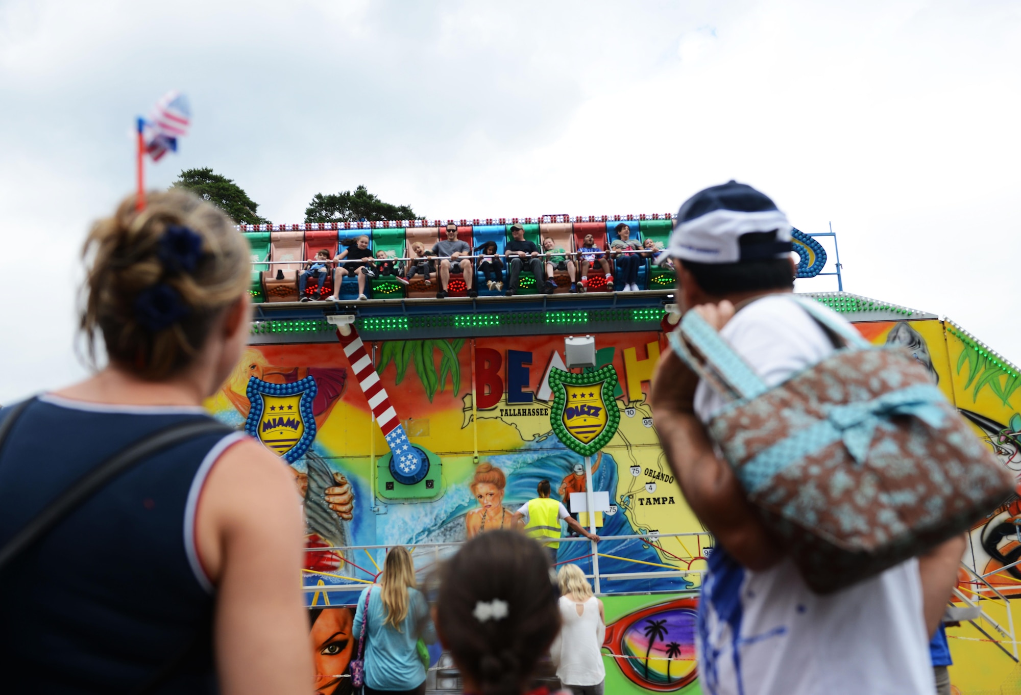 A family watches carnival goers enjoy a ride during the Freedom Fest 2016 at Ramstein Air Base, Germany, July 4, 2016. The Independence Day celebration included a variety of foods, games, rides and fireworks for Kaiserslautern Military Community members. (U.S. Air Force Photo/ Airman 1st Class Joshua Magbanua)