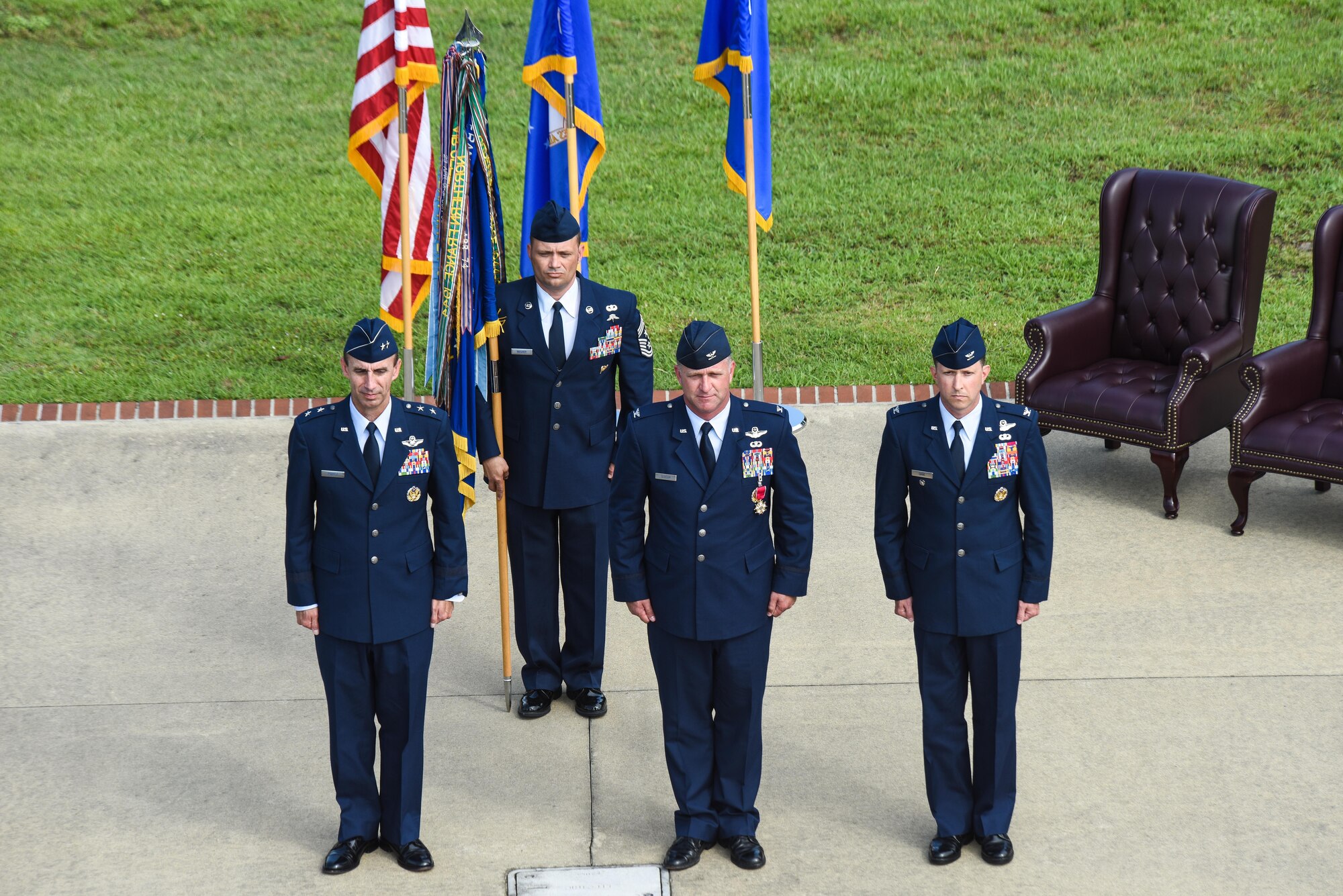 Maj. Gen. Scott Zobrist (left), Ninth Air Force commander, Chief Master Sgt. Shane Wagner (back), 4th Fighter Wing command chief, Col. Mark Slocum (center), outgoing 4th FW commander and Col. Christopher Sage (right), incoming 4th FW commander, prepare to   complete the passing of the guidon during the 4th FW change of command ceremony, June 30, 2016, at Seymour Johnson Air Force Base, North Carolina. During the ceremony, Slocum relinquished command to Sage following a two year assignment as the 4th FW commander. (U.S. Air Force photo by Airman Shawna L. Keyes/Released)