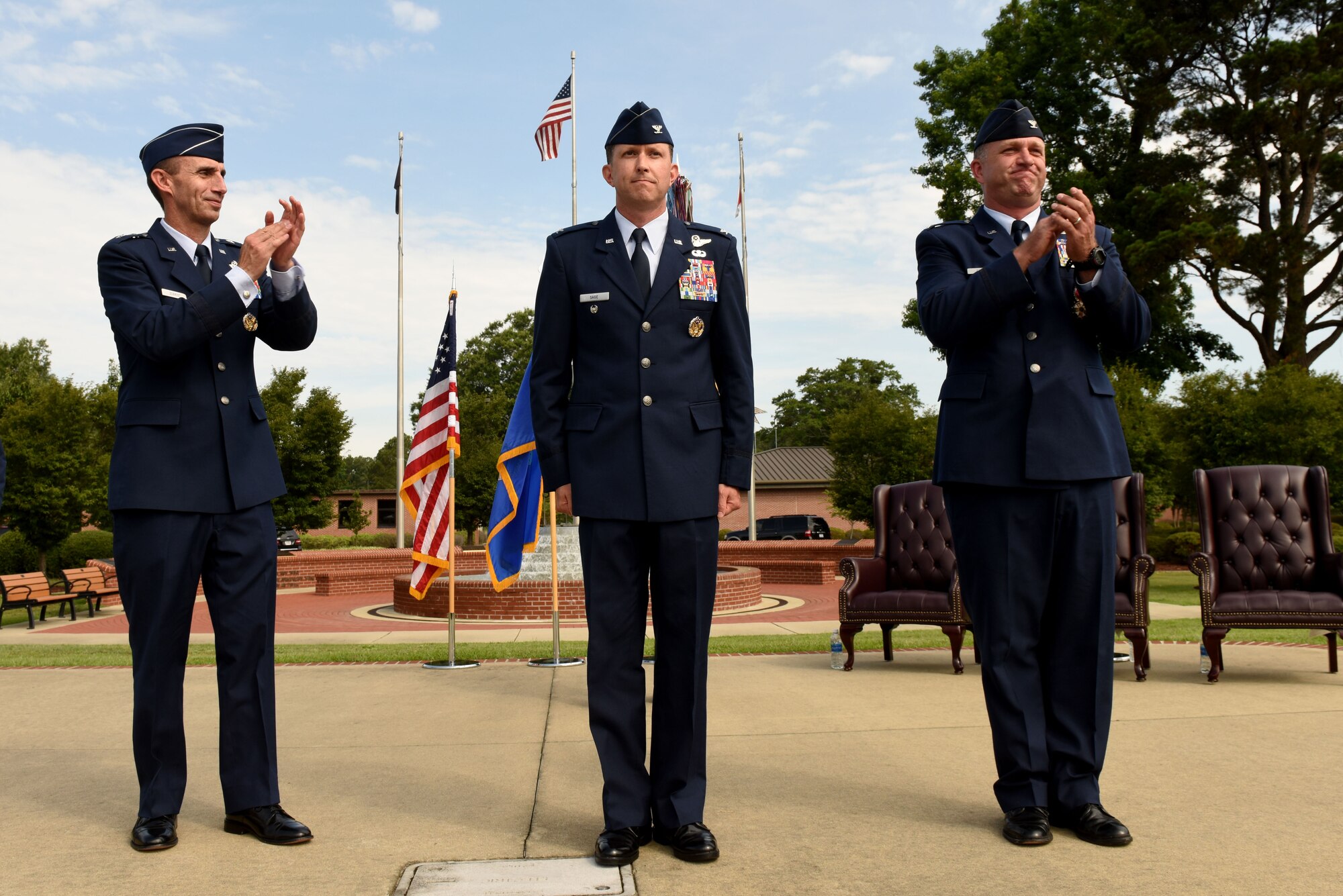 Col. Christopher Sage (center) is introduced as the new 4th Fighter Wing commander, as Maj. Gen. Scott Zobrist, Ninth Air Force commander (left), and Col. Mark Slocum (right), former 4th FW commander, applaud, June 30, 2016, at Seymour Johnson Air Force Base, North Carolina. Sage was previously the senior military assistant to the deputy chairman of the NATO Military Committee in Brussels, Belgium. (U.S. Air Force photo/Airman 1st Class Ashley Williamson)