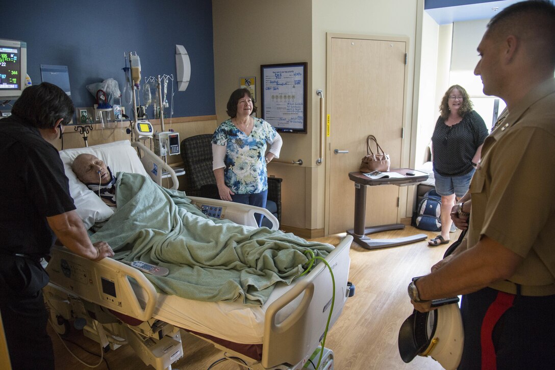 Capt. Joshua Miller, operations officer for Recruiting Station Denver, meets with the family and friends of Richard Mathis, a Marine veteran, at the St. Anthony Hospital & Medical Campus in Lakewood, CO June 29, 2016. Mathis suffered a broken neck from a fall that occurred approximately three weeks prior to the visit.