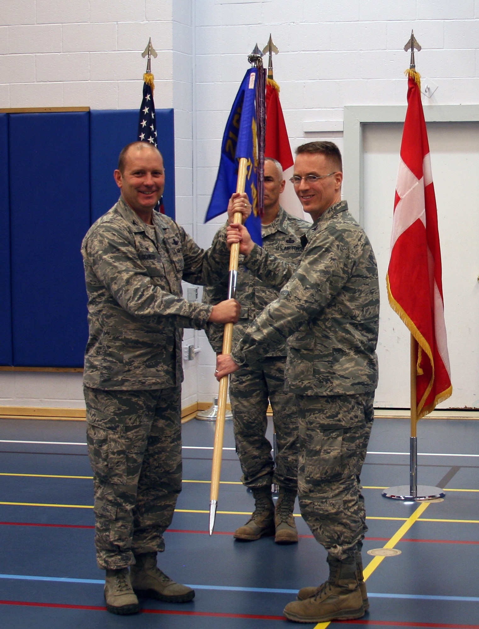 THULE AIR BASE, Greenland – Col. Doug Schiess, 21st Space Wing commander, presents the guidon to Col. Christopher Eagan, 821st Air Base Group commander, during a change of command ceremony at Thule Air Base, Greenland on June 28, 2016. As the 821st ABG commander, Eagan is responsible for the administration and security of the Thule Defense Area, the Air Force's largest overseas and the United States' northernmost military installation. (U.S. Air Force photo by Master Sgt. Stoney Bair)