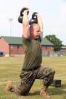 Staff Sgt. Jason Tanner, division chief for the ground support element with Marine Aviation Logistics Squadron 29, executes kettlebell lunges in the tactical shuttle at the Tactical Athlete Competition on Marine Corps Air Station New River June 24. The competition served as the qualifying competition, where top male and female Marines from each installation would have the opportunity to compete for the finals at Miramar. (U.S. Marine Corps photo by Cpl. Mark Watola /Released)