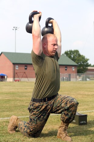 Staff Sgt. Jason Tanner, division chief for the ground support element with Marine Aviation Logistics Squadron 29, executes kettlebell lunges in the tactical shuttle at the Tactical Athlete Competition on Marine Corps Air Station New River June 24. The competition served as the qualifying competition, where top male and female Marines from each installation would have the opportunity to compete for the finals at Miramar. (U.S. Marine Corps photo by Cpl. Mark Watola /Released)