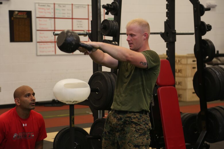 Staff Sgt. Jason Tanner, division chief for the ground support element with Marine Aviation Logistics Squadron 29, executes kettlebell swings at the Tactical Athlete Competition on Marine Corps Air Station New River June 24. The competition served as the qualifying competition, where top male and female Marines from each installation would have the opportunity to compete for the finals at Miramar. (U.S. Marine Corps photo by Cpl. Mark Watola /Released)