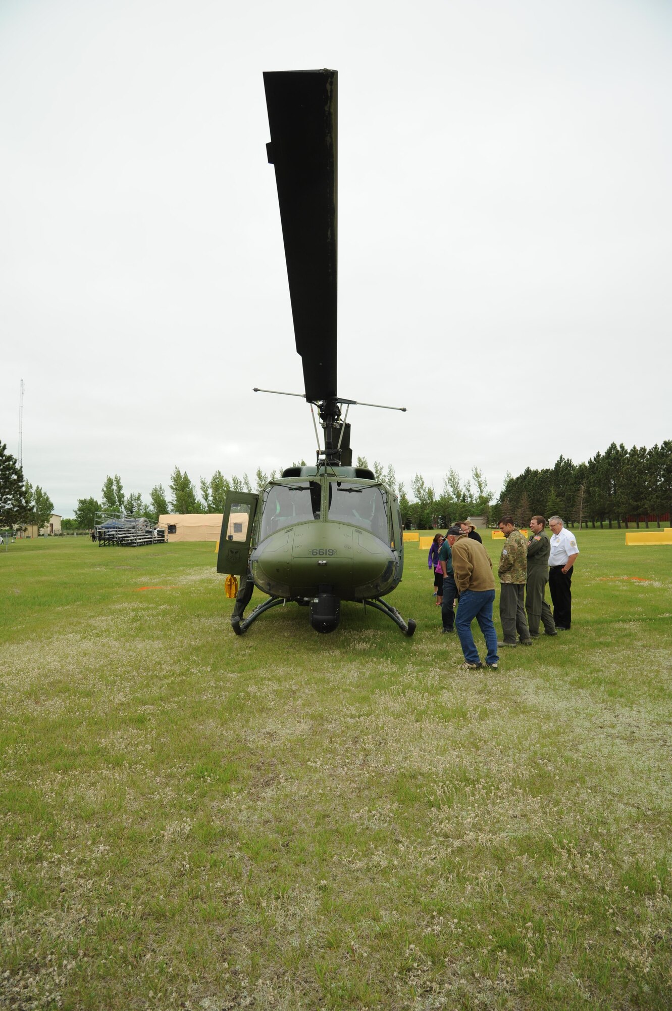 CAVALIER AIR FORCE STATION, N.D. – Open house guests speak with the crew of an UH-1N Huey helicopter on Cavalier Air Force Station, N.D., June 11, 2016. The crew belongs to the 54th Helicopter Squadron from Minot Air Force Base, N.D., and the craft was flown in to support an open house for the local community. (U.S. Air Force photo by Senior Airman Ryan Sparks)