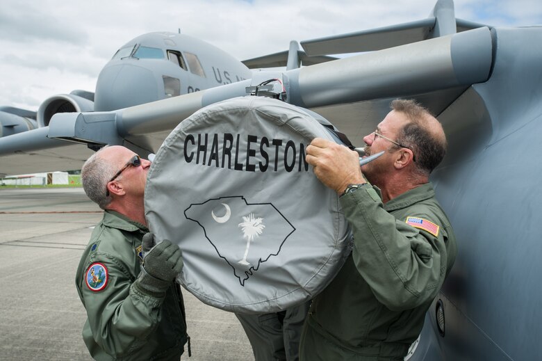 Lt. Col. Craig Bartosh, 701st Airlift Squadron pilot, helps Chief Master Sgt. Bryan DuBois, 317th Airlift Squadron loadmaster superintendant, mount one of the engines onto the mini C-17 at the Yeovilton Air Day July 2. This is the 315th AWs second time visiting Yeovilton, England and this year, the presence of the mini C-17 helped seal the deal for another “Best Static Display” award. (U.S. Air Force photo by Master Sgt. Shane Ellis)