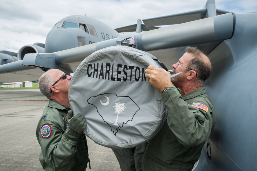 Lt. Col. Craig Bartosh, 701st Airlift Squadron pilot, helps Chief Master Sgt. Bryan DuBois, 317th Airlift Squadron loadmaster superintendant, mount one of the engines onto the mini C-17 at the Yeovilton Air Day July 2. This is the 315th AWs second time visiting Yeovilton, England and this year, the presence of the mini C-17 helped seal the deal for another “Best Static Display” award. (U.S. Air Force photo by Master Sgt. Shane Ellis)