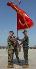 Col. Timothy M. Salmon, outgoing commanding officer, Marine Corps Air Station New River, passes the air station’s colors to Col. Russell C. Burton, symbolizing the transition of leadership during a change of command ceremony at MCAS New River June 23. Col. Salmon relinquished his command of the air station after three years of service as the air station’s commander. 