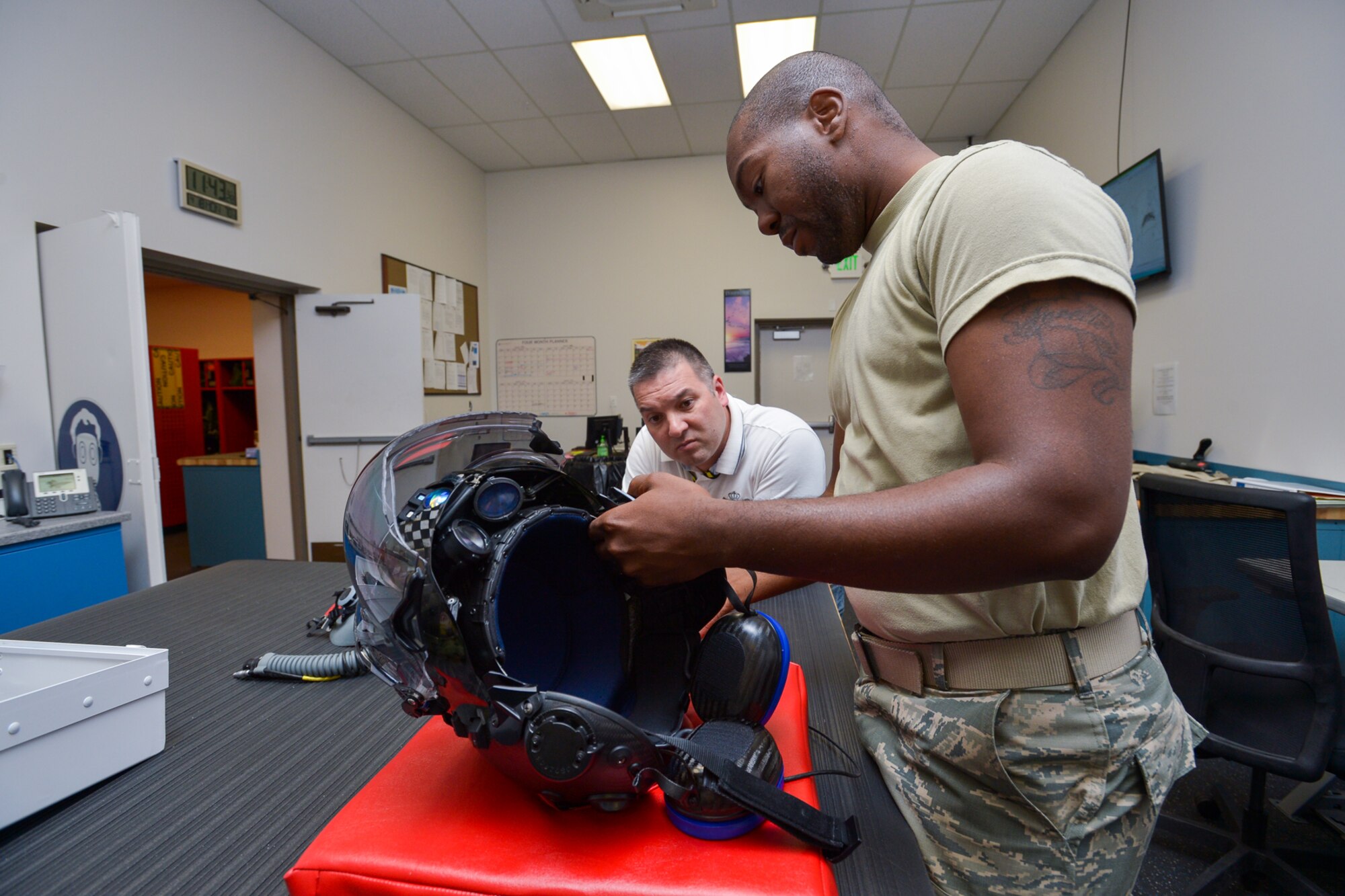 Staff Sgt. Joseph Hicks, 419th Operations Support Flight, trains coworker Nolan Cooney on how to inspect an F-35 helmet to ensure it is in working order. Hicks is the first reservist at Hill Air Force Base to work with the new high-tech helmet. (U.S. Air Force photo/R. Nial Bradshaw)