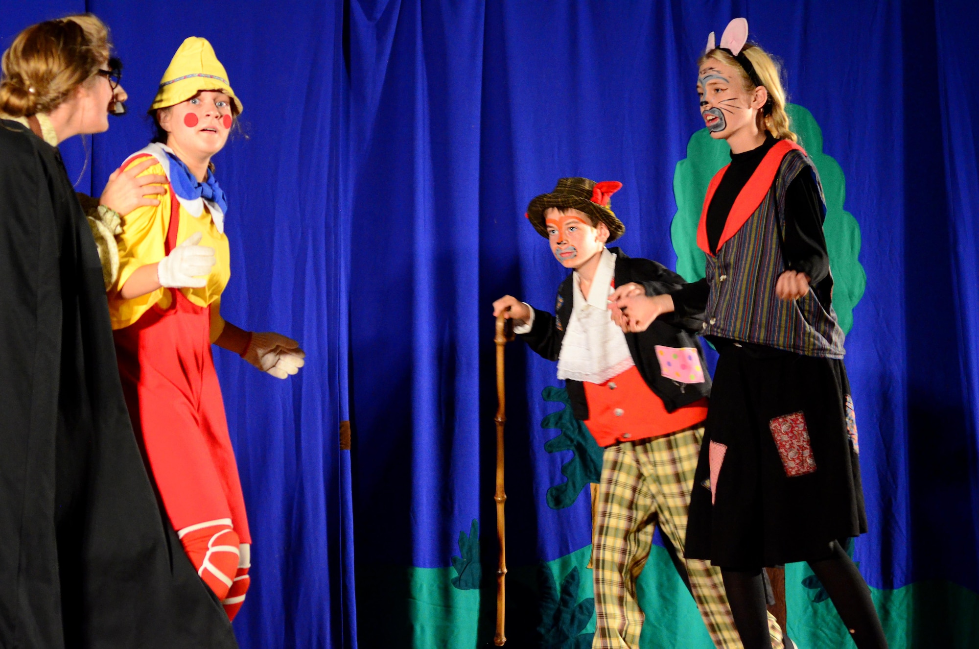 Pinocchio (Natalie Moran) is caught between his enemies, the evil puppet master Stromboli (Kate Kessler), the wicked Cat (Annika Sederburg) and Fox (Adam Balts) during the Missoula Children’s Theatre presentation of Pinocchio at the base theater on Peterson Air Force Base on July 1, 2016. Seventeen children from the bases Youth Center, filling the roles of 60 children, had five days to learn and perform the musical presentation of Pinocchio. (U.S. Air Force photo by Staff Sgt. Amber Grimm)