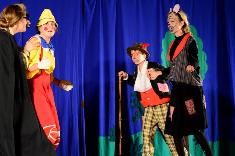 Pinocchio (Natalie Moran) is caught between his enemies, the evil puppet master Stromboli (Kate Kessler), the wicked Cat (Annika Sederburg) and Fox (Adam Balts) during the Missoula Children’s Theatre presentation of Pinocchio at the base theater on Peterson Air Force Base on July 1, 2016. Seventeen children from the bases Youth Center, filling the roles of 60 children, had five days to learn and perform the musical presentation of Pinocchio. (U.S. Air Force photo by Staff Sgt. Amber Grimm)