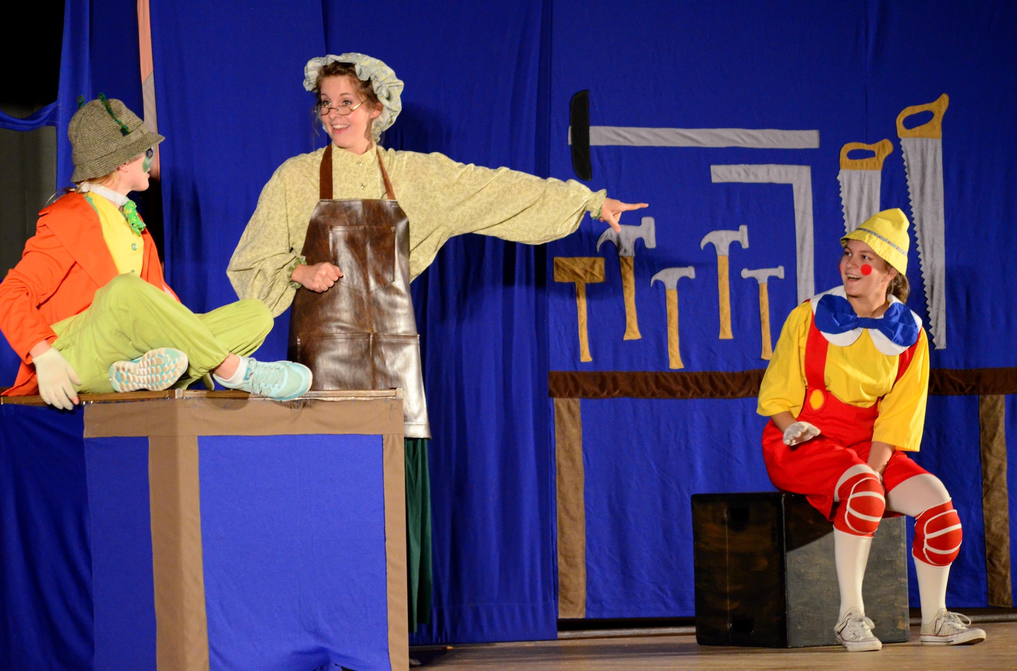 Mrs. Geppetto (Kate Kesslar) introduces Jiminy Cricket (Olivia Armstrong) to Pinocchio (Natalie Moran) during the Missoula Children’s Theatre presentation of Pinocchio at the base theater on Peterson Air Force Base on July 1, 2016. In a single year MCT has around 65,000 cast members, ages 5-18, performing before 750,000 people in all 50 states and 17 different countries. (U.S. Air Force photo by Staff Sgt. Amber Grimm)