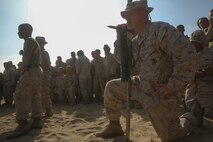 Lieutenant Colonel Michael Nakonieczny, the commanding officer of Headquarters Battalion, 1st Light Armored Reconnaissance Battalion, 1st Marine Division, knees down with the battalion’s Highlander Sword while Marines fight using pugil sticks during 1st LAR’s Highlander Night aboard Marine Corps Base Camp Pendleton, Calif., June 30, 2016. The Highlander Night tightens the bonds of brotherhood through competitions that pit unit against unit. (U.S. Marine Corps photo by Lance Cpl. Timothy Valero/ Released)