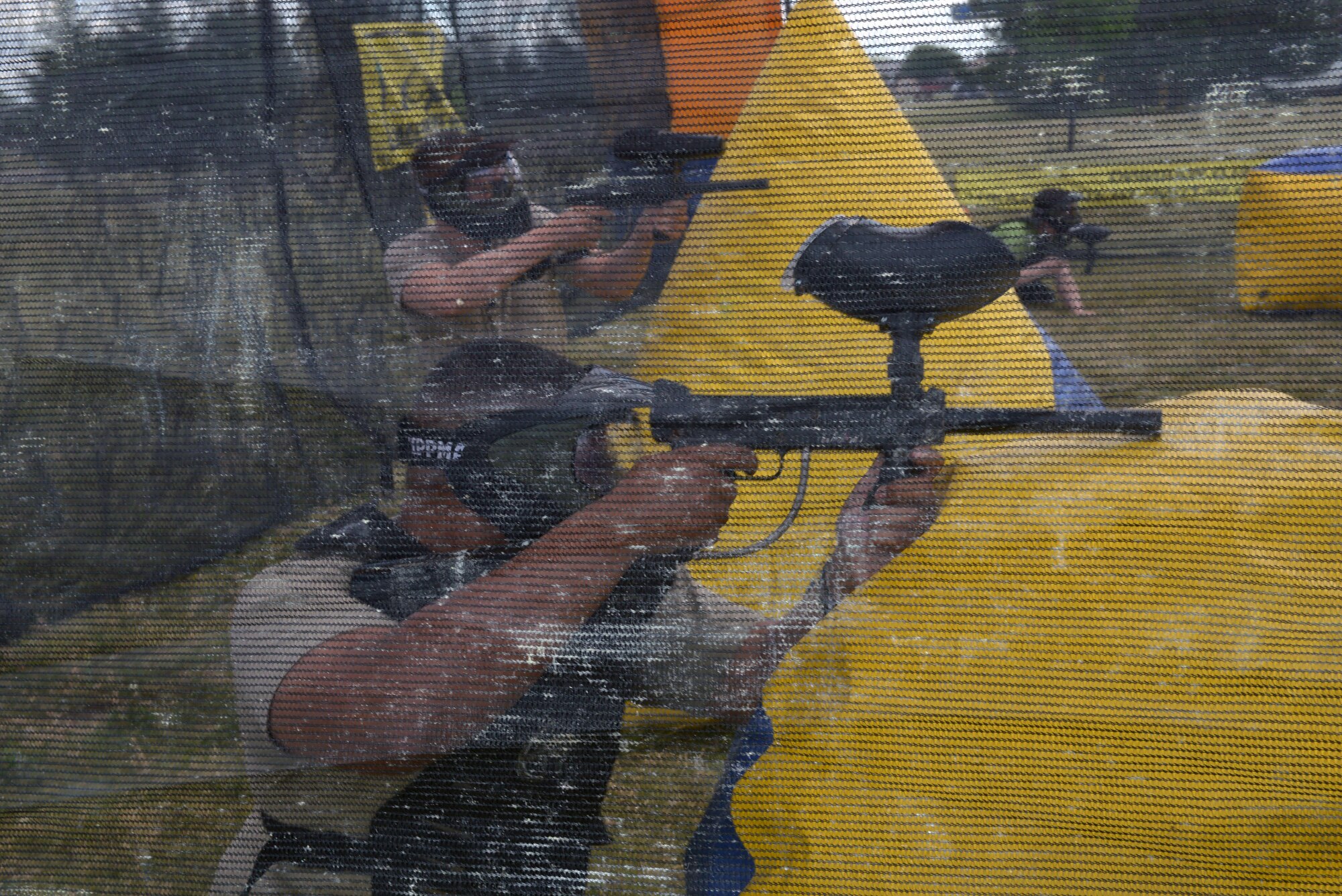 Airmen attending the annual base picnic engage in a game of paintball at Ellsworth Air Force Base, S.D., June 30, 2016. Participants wore protective masks and clothing while wielding paintball guns and firing different colored paints to identify opposing teams, allowing all a chance to participate. (U.S. Air Force photo by Airman Donald Knechtel/Released)