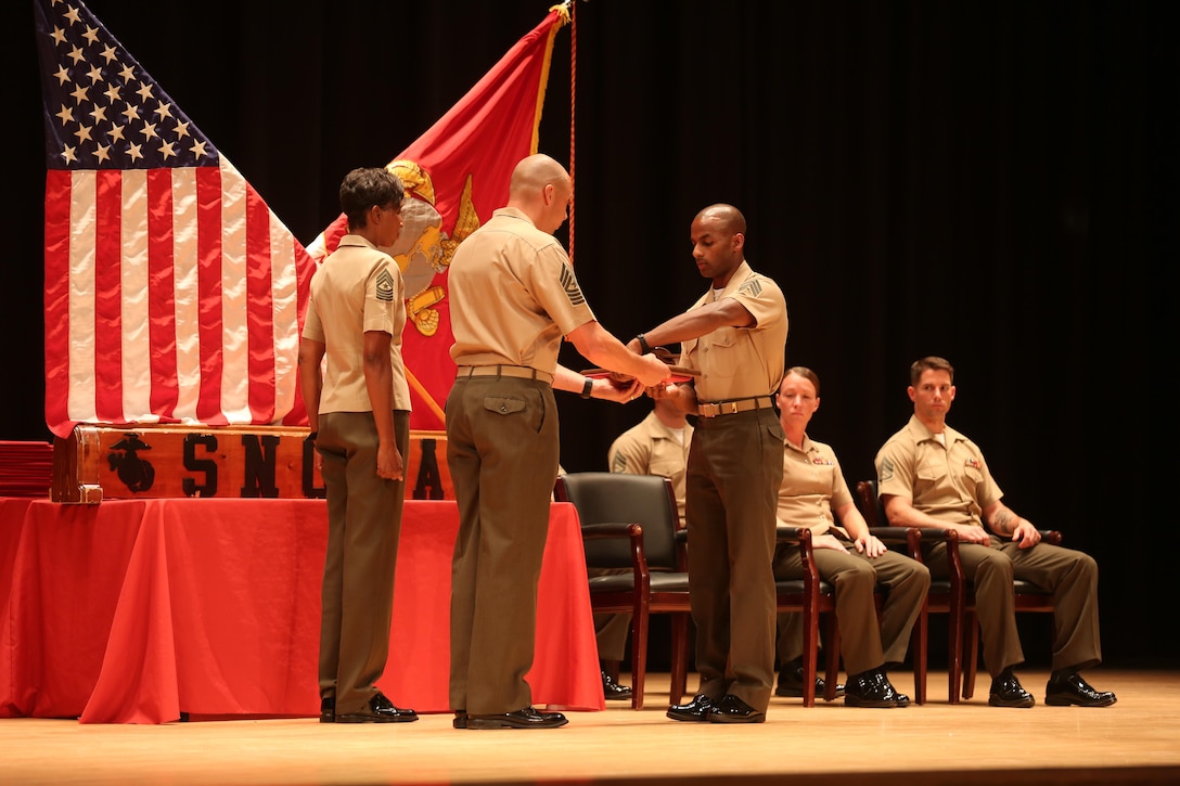 Sgt. Ricky Hassan, gung ho recipient from Sergeant’s Course class 14-16, receives an award for excellence among his peers during the course graduation at the Base Theater on Marine Corps Base Camp Lejeune June 10. Sergeant’s Course is one of many formal professional military education courses run by the Staff Noncommissioned Officer Academy to enhance the overall Marine, who in turn can give back to their units. (U.S. Marine Corps photo by Cpl. Mark Watola /Released)