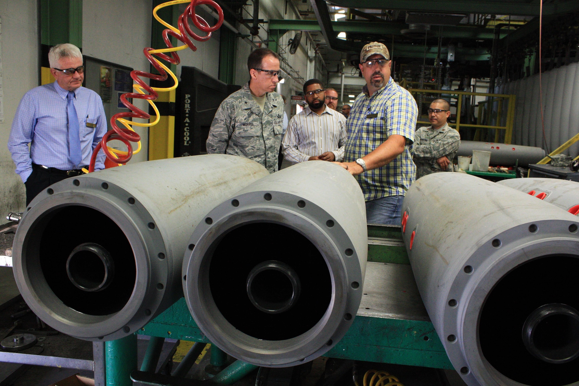 Jerry Lovell, area supervisor in the Industrial Operations Division, talks to Air Force Brig. Gen. Shaun Morris, Program Executive Office for Weapons at Eglin Air Force Base, Fla., about general purpose bomb preparation during a visit to McAlester Army Ammunition Plant, Okla., June 13. (Photo Credit: Kevin Jackson (AMC))