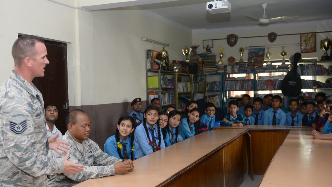 Tech. Sgt. Randy Walgren, 36th Mobility Response Squadron aerial porter, introduces himself to Nepali students during a community outreach event July 4, 2016, in Kathmandu, Nepal. The community outreach event consisted of a question and answer session with Airmen from the 36th Contingency Response Group and the opportunity to play sports with one another. (U.S. Air Force photo by Staff Sgt. Benjamin Gonsier/Released)