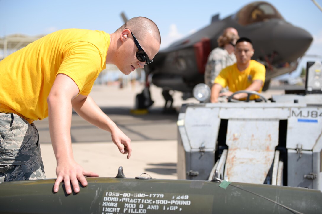 Staff Sgt. Mark Beyer, 61st Aircraft Maintenance Unit load crew leader, and Airman 1st Class Theodore Reyes, 61st AMU load crew member, prepare an inert bomb for loading onto an F-35 during the annual Second Quarter Load Crew Competition July 1, 2016, at Luke Air Force Base, Ariz. The competition pitted teams from different AMUs against each other in a race to complete the loading of weapons onto either an F-16 or an F-35 first. (U.S. Air Force photo by Airman 1st Class Ridge Shan)
