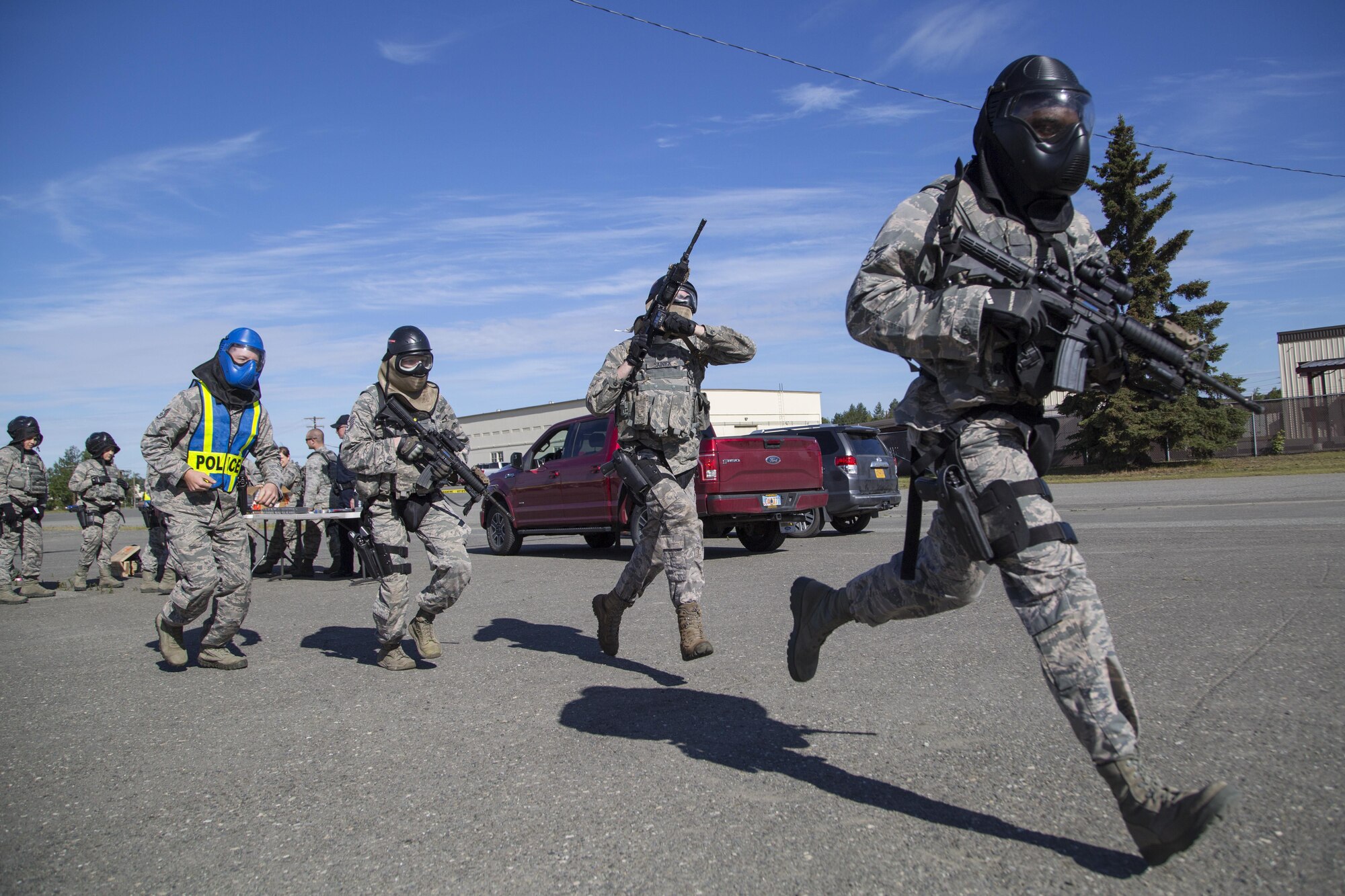 Security forces personnel, assigned to the 673d Security Forces Squadron, rush to breach a building while conducting high risk response training at Joint Base Elmendorf-Richardson, Alaska, June 29, 2016. High risk response training provides security forces personnel an intensive, hands-on course based in various real-life scenarios emphasizing effective tactics to engage and eliminate active shooters or other threats. (U.S. Air Force photo/Alejandro Pena)