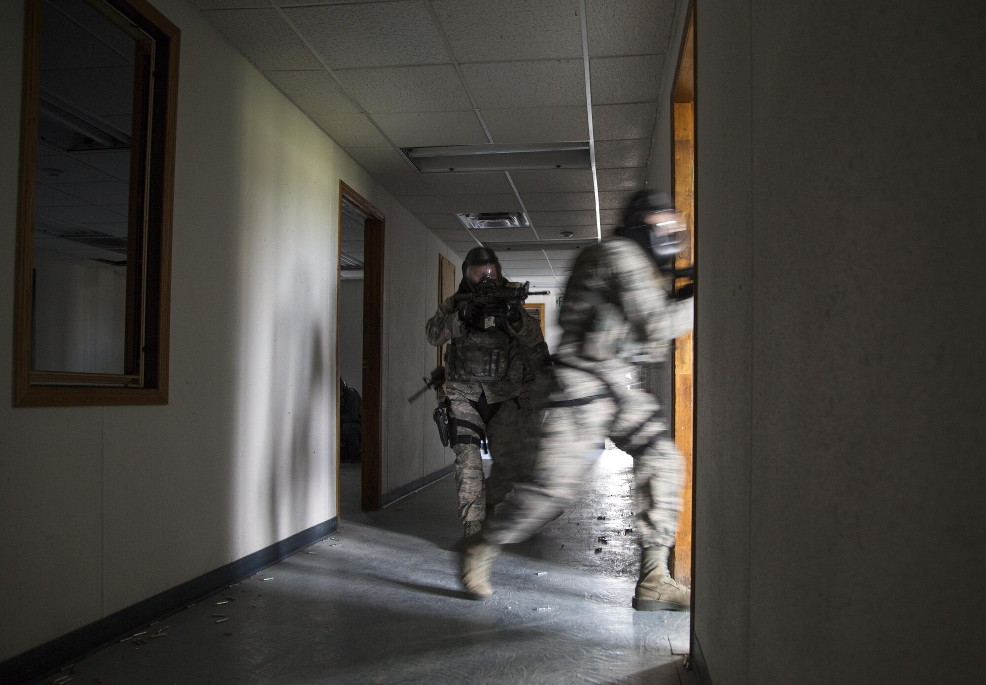 Security forces personnel, assigned to the 673d Security Forces Squadron, search a building for active threats while conducting high risk response training at Joint Base Elmendorf-Richardson, Alaska, June 29, 2016. High risk response training provides security forces personnel an intensive, hands-on course based in various real-life scenarios emphasizing effective tactics to engage and eliminate active shooters or other threats. (U.S. Air Force photo/Alejandro Pena)
