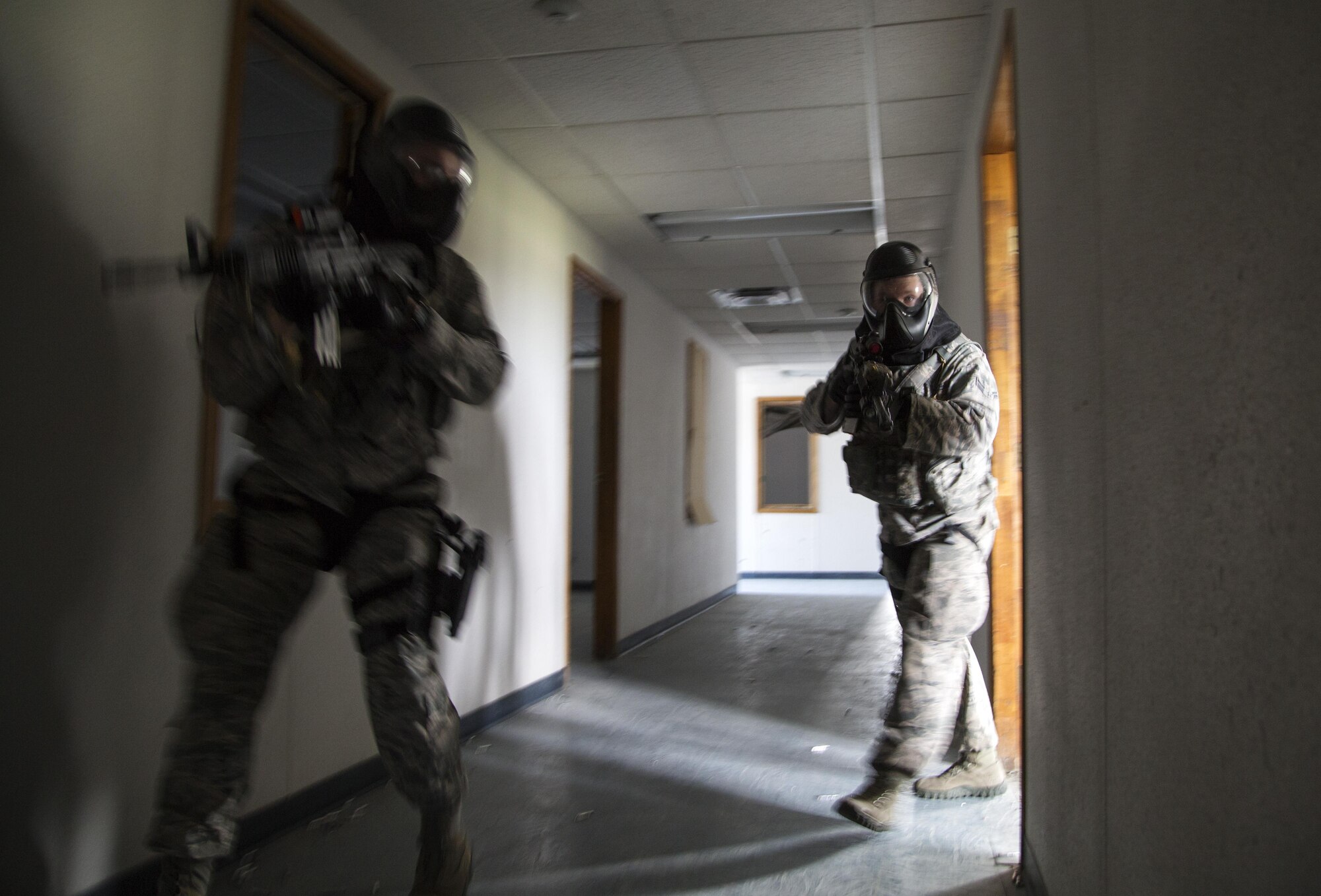 Security forces personnel, assigned to the 673d Security Forces Squadron, search a building for active threats while conducting high risk response training at Joint Base Elmendorf-Richardson, Alaska, June 29, 2016. High risk response training provides security forces personnel an intensive, hands-on course based in various real-life scenarios emphasizing effective tactics to engage and eliminate active shooters or other threats. (U.S. Air Force photo/Alejandro Pena)