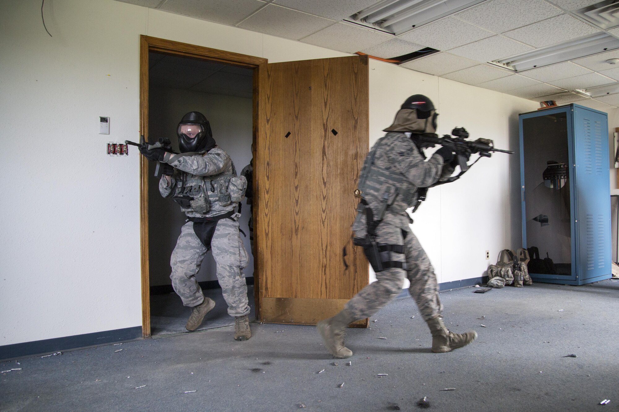 Security forces personnel, assigned to the 673d Security Forces Squadron, clear a room of active threats while conducting high risk response training at Joint Base Elmendorf-Richardson, Alaska, June 29, 2016. High risk response training provides security forces personnel an intensive, hands-on course based in various real-life scenarios emphasizing effective tactics to engage and eliminate active shooters or other threats. (U.S. Air Force photo/Alejandro Pena)