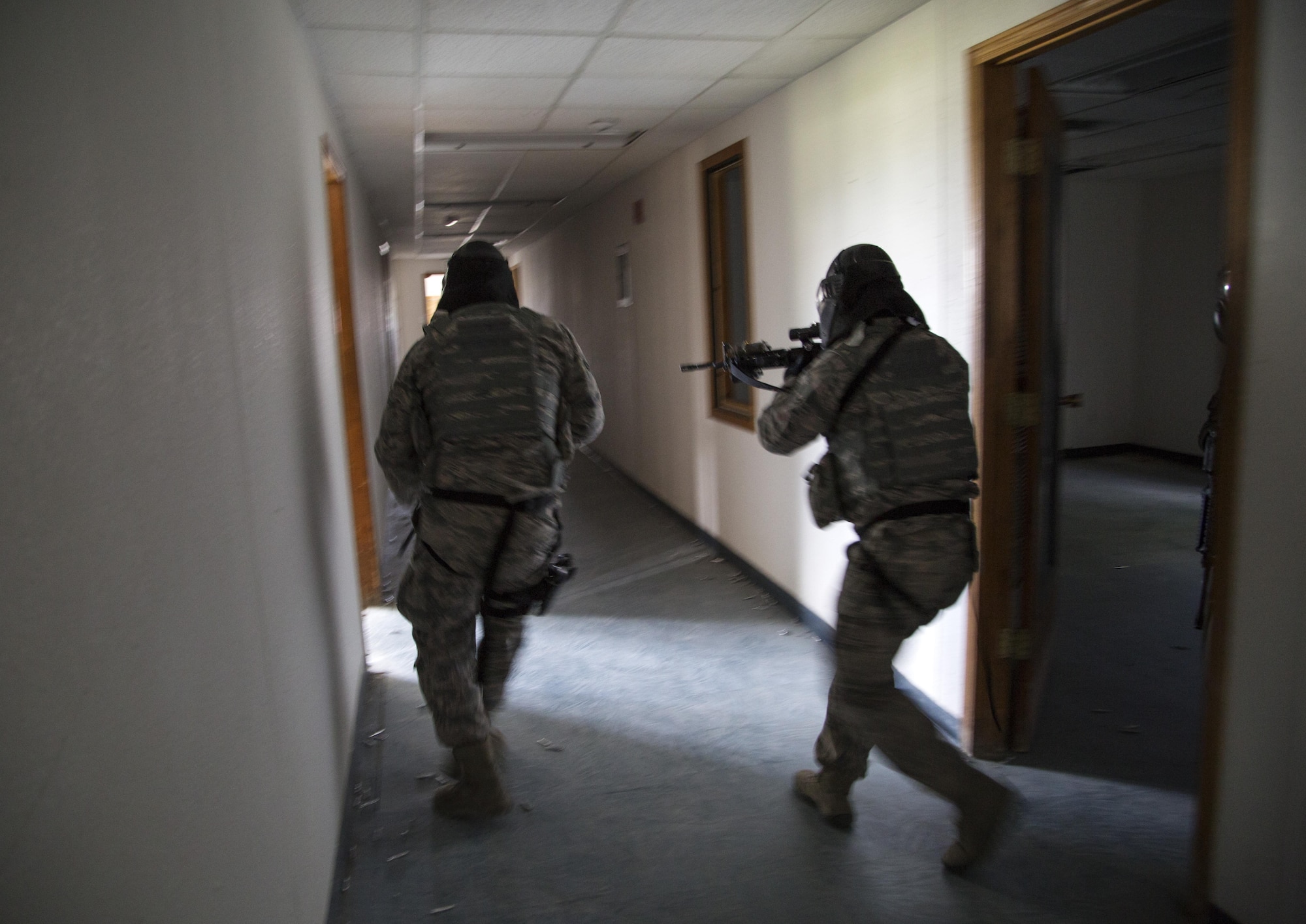 Security forces personnel, assigned to the 673d Security Forces Squadron, search and clear a building of active threats while conducting high risk response training at Joint Base Elmendorf-Richardson, Alaska, June 29, 2016. High risk response training provides security forces personnel an intensive, hands-on course based in various real-life scenarios emphasizing effective tactics to engage and eliminate active shooters or other threats. (U.S. Air Force photo/Alejandro Pena)