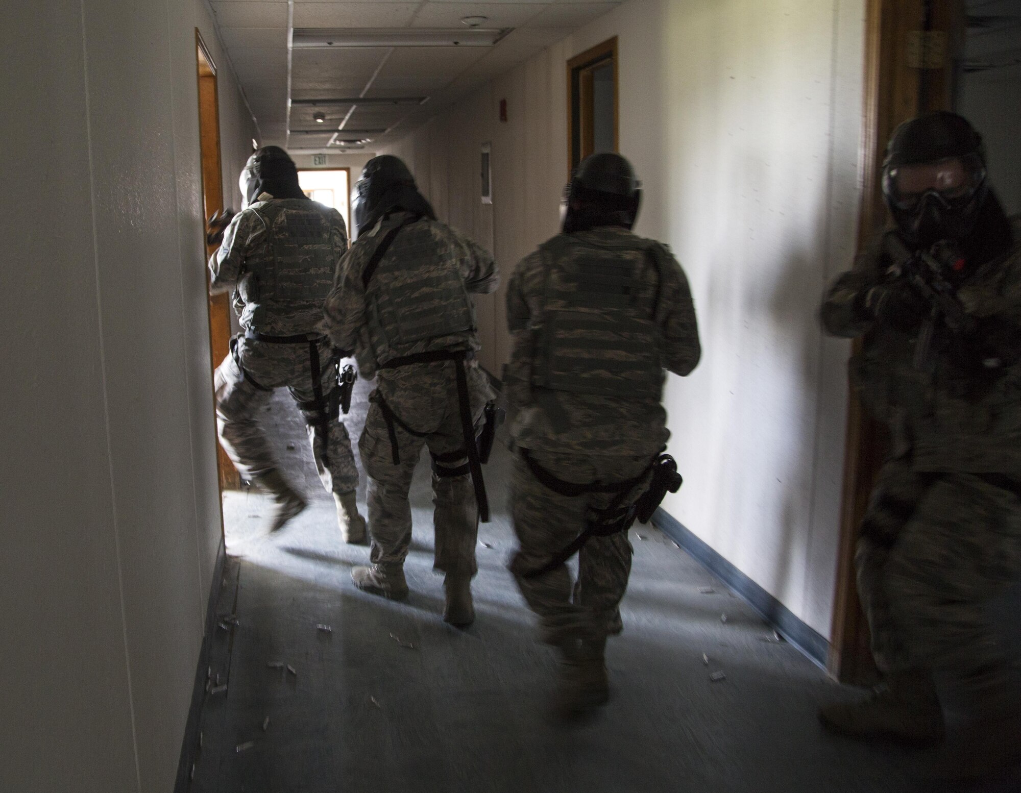 Security forces personnel, assigned to the 673d Security Forces Squadron, search and clear a building of active threats while conducting high risk response training at Joint Base Elmendorf-Richardson, Alaska, June 29, 2016. High risk response training provides security forces personnel an intensive, hands-on course based in various real-life scenarios emphasizing effective tactics to engage and eliminate active shooters or other threats. (U.S. Air Force photo/Alejandro Pena)